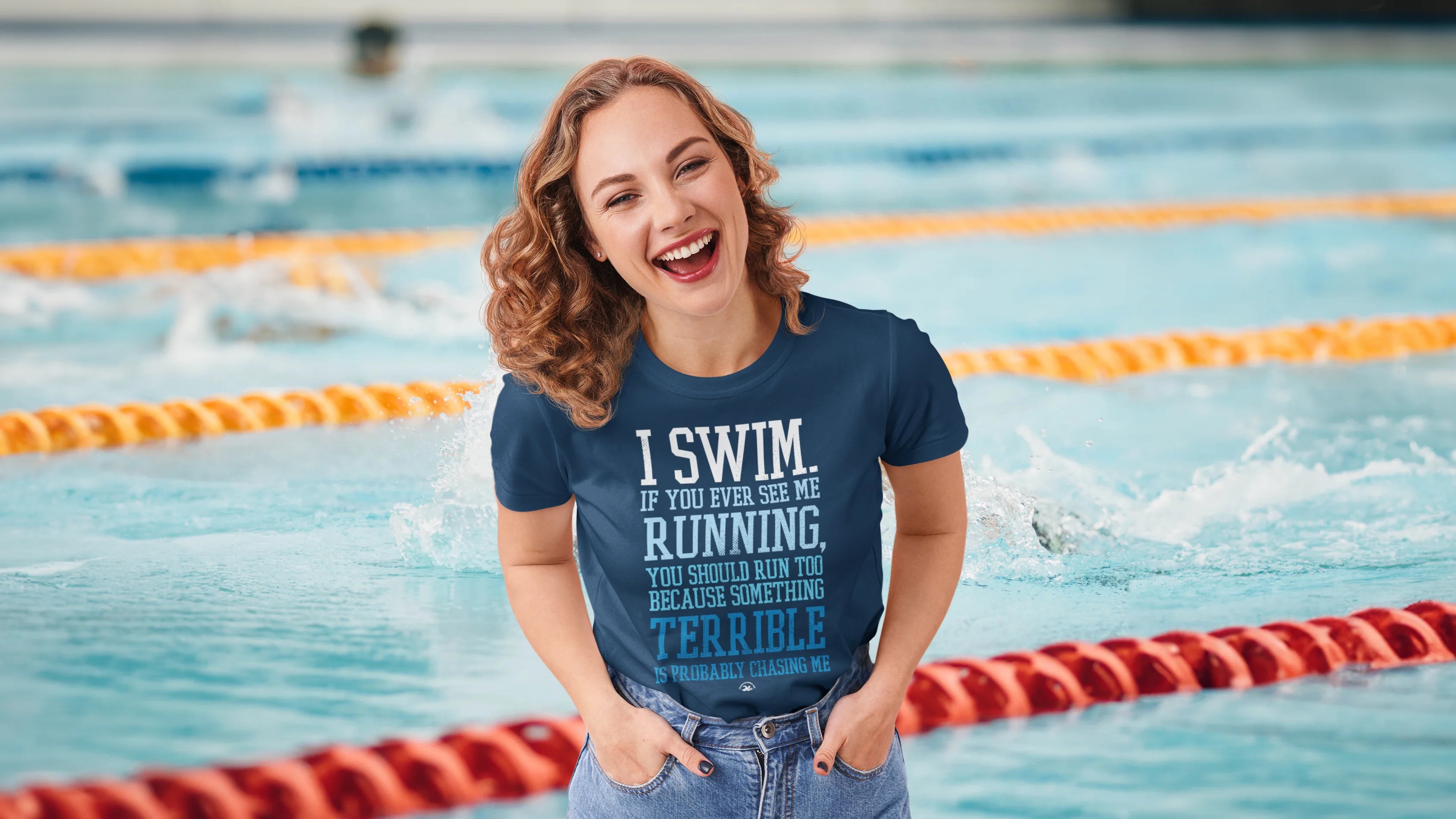 a woman laughing in a t shirt in front of a swimming pool