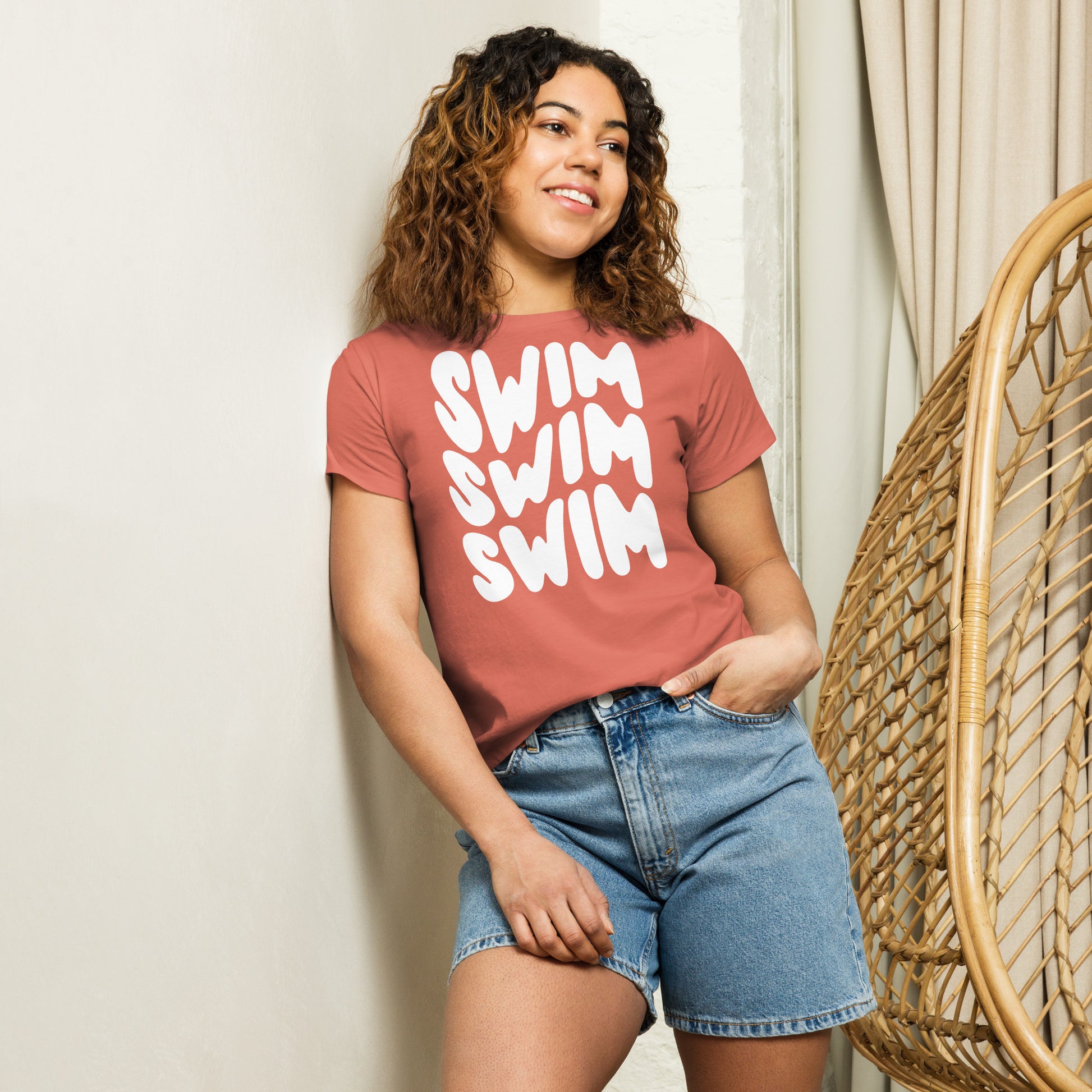 young lady in a swim themed t-shirt leaning against a way